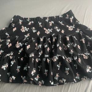 Svart kjol - Svart, kort, blommig kjol, använts 2 gånger, i bra skikt