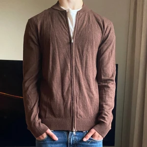 John Henric Full Zip | Merino - En riktigt najs full zip från John Henric i röd/brun färg i Merino perfekt inför hösten. Riktigt fint skick utan defekter, storleken är S. Modellen på bilden är 175 cm. Nypriset är runt 900kr, mitt pris 350kr. Hör av er vid eventuella funderingar!👏👌