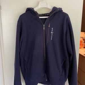 En snygg Sail Racing hoodie Navy, utmärkt skick, nästintill oanvänd! Väldigt populär med ett nypris på 1500kr