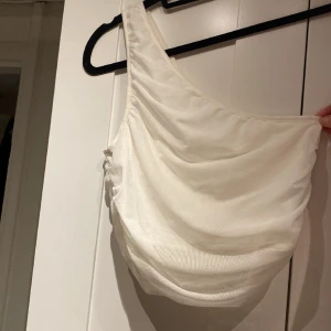 One shoulder linne - Ett vitt One shoulder linne från Nakd och knappt använt. 