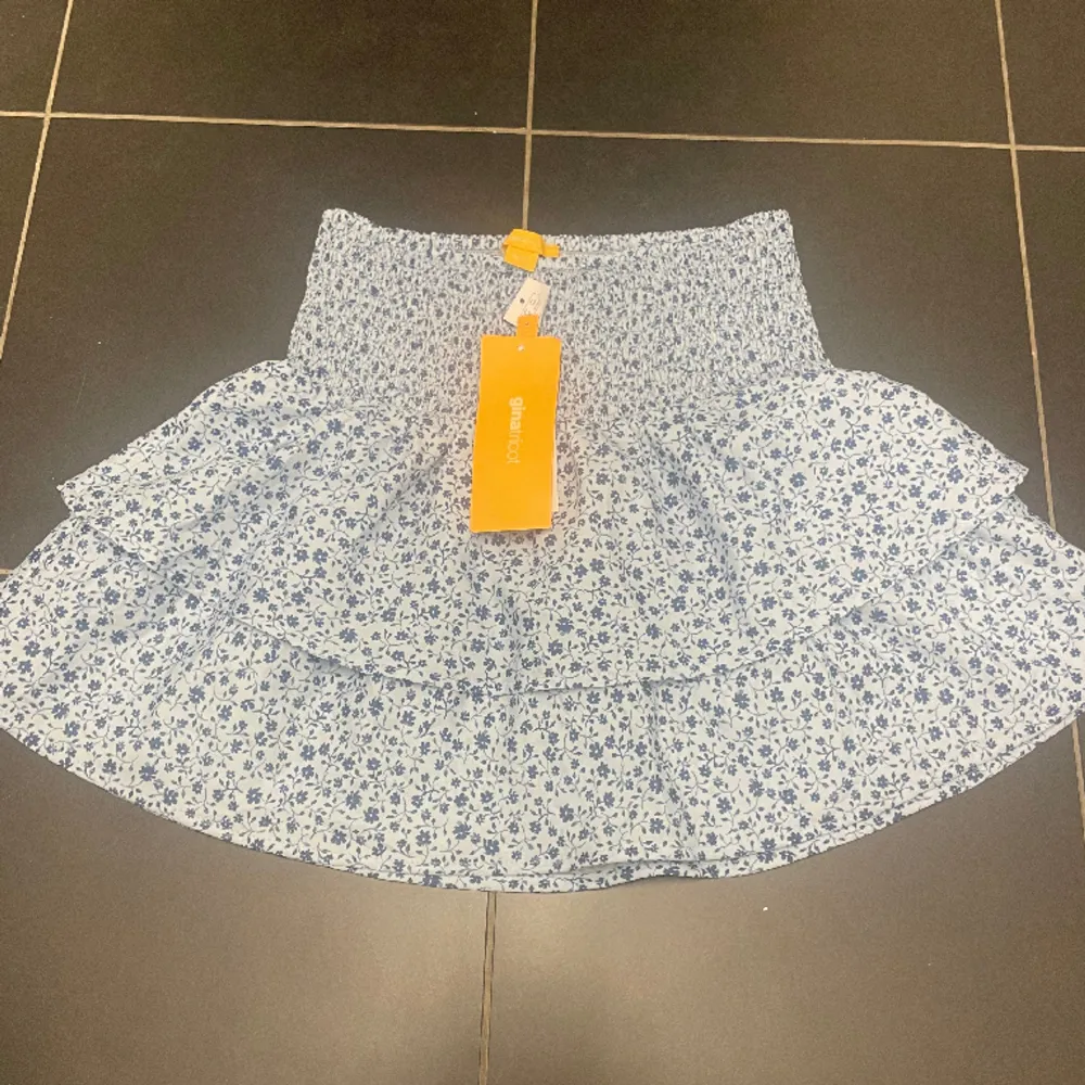 Säljer denna vilangkjol ifrån GinaTricot. Denna är ny med prislapp och aldrig använd. Blå med ett fint blommigt mönster i storlek 158/164. Perfekt till i sommar!!. Kjolar.