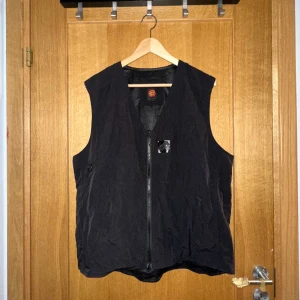 Santa Cruz Väst - 100% crinkle nylon, normal passform, dragkedja baktill, litet tryck på bröstet och ryggen. Knappt använd