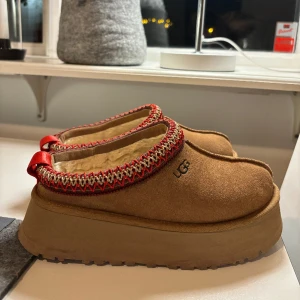 Ugg Tazz ’Chestnut’  - Ugg Tazz Slipper i färgen Chestnut som tyvärr inte kommer till användning länge då jag köpt ett par andra. Skorna är sparsamt använda och därmed i fint skick! Inköpspris runt 2000, mitt pris 1100 eller högsta bud! 