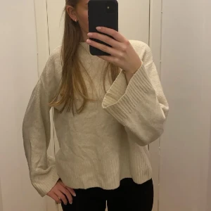 Stickad tröja med slits - Säljer denna beiga stickade tröja med slits från pull & bear. Är i storlek s men skulle säga att den mer sitter som en xs.