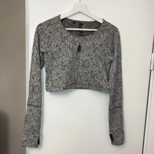 Croppad träningstopp  - Träningstopp från Gymshark som är croppad, så snygg! Perfekt med gjorda hål för tummarna, så skönt i kylan! Som ny. 