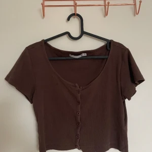 Brun urringad t-shirt  - Storlek M från lager 157. Köparen står för eventuell frakt 