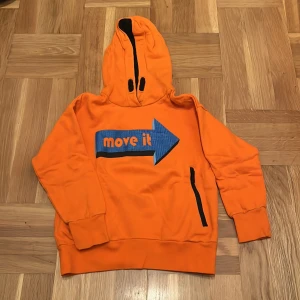 Luvtröja  - Orange luvtröja men ficka på magen 