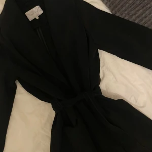 Svart kappa - Medellång svart kappa från VILA i stl S. Har använts ett fåtal gånger, den är i gott skick. 