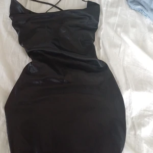 Svart glansig klännig - Slutar på typ halva låren *på mig), men använde en gång men den va lite kort när ja satt mig, men fin och ger figur. (Öppen rygg med sicksack snören). Som sagt jätte bra skick därav d dyra priset. Passar t utekvällar, halloween, fester etc.