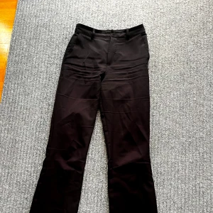 Svarta kostymbyxor - Svarta kostymbyxor, på bilden ser dom nästan lite lila aktiga ut men dom är helt svarta. Slutar ungefär precis under naveln så hyfsat högmidjade