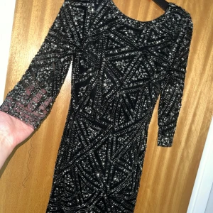 Svart/glittrig festklänning  - 🌟Använd 1 gång  🌟Silverglittrig 🌟Djup v- ringning i ryggen  🌟Kortklänning  🌟Armarna syns ”igenom”  🌟Bekväm 🌟Storlek XS men skulle säga mer som Xxs