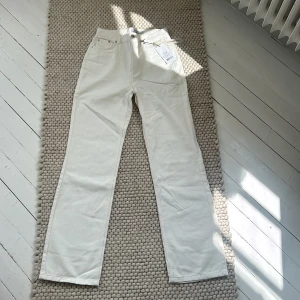 Beiga/vita byxor från Na-Kd - ”Highwaist Wide Leg Denim” från Na-Kd. Jättefina byxor i storlek 36, aldrig använda med prislappen kvar. Färgen heter ePARK White