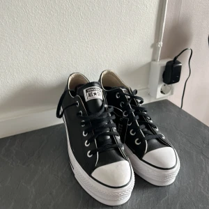 Oanvända platå Converse i skinn  - Enbart provade hemma, prislapp sitter kvar.  oanvända Svarta Converse i skinn med platå, strl 39 (24,5 cm) säljes.