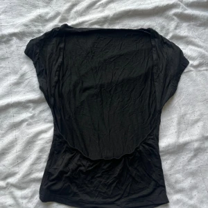 Svart t shirt - Svart tight t shirt med öppen rygg, köpt för 100 säljs för 30kr aldrig använd