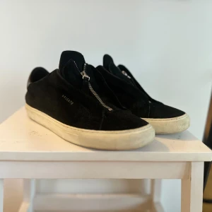 Axel arigato sneakers strl 43 US10 - Axel Arigato zip skor. Ingen påse eller box medföljer  Storlek 43 fräscha utom att tyget har har släppt lite grann vid dragkedjan (se bild) på båda skorna. Annars jättefräscha använd under denna sommar.