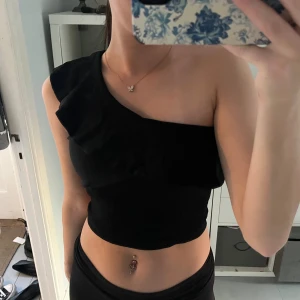 Söt topp - En jättefin topp med one shoulder och volang! Köpt för länge sen men har använt tröjan endast en gång! 💕 Storlek 40 men passar mig som har S/Xs