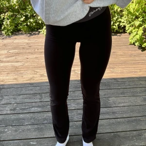 Pineapple bootcut yogabyxor - Svarta, sköna yogabyxor, med grått midjeband samt bootcut från dansskolan ”Pineapple” i London. Logga på höger höft. Storlek: XS (fungerar även för mig som har S/M i byxor). Material: 95% bomull + 5% elastan. :)