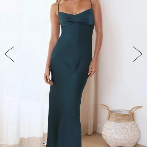 Vacker mörkgrön satin maxi klännibg - Säljer denna superfina klänning från Hello Molly som köptes i våras. Den har superfin snörning i ryggen som gör att man kan anpassa passformen. Aldrig använd. Liten i storlekpassar s/xs. 132 cm hela vägen ner mätt från måttbandet i den sista bilden! 
