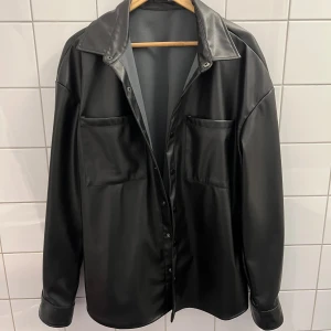 Skinn skjorta  - En svart skinn skjorta i storlek L. Köpt i mars och har knappt hunnit använda den. Riktigt cool och nice skjorta, fungerar som overshirt eller regn kappa. Lite 90-tals vibe och kan stylas på flera sätt