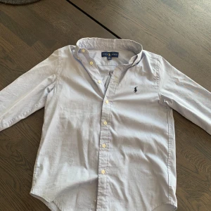 Ralph Lauren skjorta - Detta är en Ralph Lauren skjorta i ljusblå. Den är autentisk och hufsat bra skick med en ytterst liten fläck som går bort i en tvätt👍