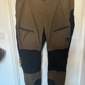 Friluftsbyxor - Friluftsbyxor med fler fickor och mesh fickor på sidorna som man kan öppna och stänga för att få luft 