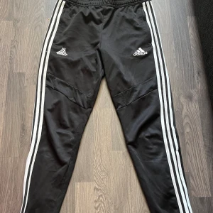 Adidas byxor - Ett par adidas byxor, använda mycket och tror de blivit lagade men det är inget som märks. Lite repade på knäna, annars fina. Ingen lapp finns kvar och köpta för flera år sen, men skulle gissa att det är 170 på de.  Skriv för mer info eller bilder!💕