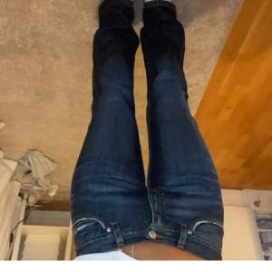 Mörkblåa jeans som är lågmidjade och bootcat! I mycket fint skick, innerbenslängden är ca 80 cm (uppsprättade längst ner)!