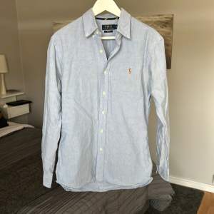 En ljusblå Polo Ralph Lauren skjorta i felfritt skick. Slimfit! Nypris runt 1700kr, säljes då den ej kommer till användning längre.