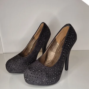 Svarta platåpumps med strass  - Svarta platåpumps med strass från Dinsko. st 37 . klackhöjd 13 cm Lagom användning 