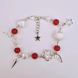 Rött armband med silverdetaljer - Handgjort armband. Röda glaspärlor, vita akrylpärlor och silverdetaljer (ej äkta). 16 cm i storlek men kan ändras efter önskemål. 