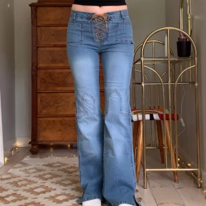 Vintage jeans - Lågmidjade utsvängda jeans med snörning, detaljer på knäna och små slitsar nertill, från märket Cooker’s! Jag är 173 cm, midjemåttet är 72 cm (strechiga) och innerbenslängden 81 cm 🖤