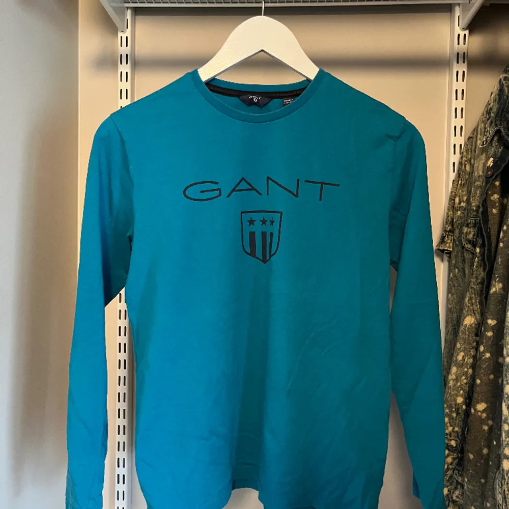 Snygg ljusblå långärmad Gant tröja. Storlek 158/164cm.. T-shirts.