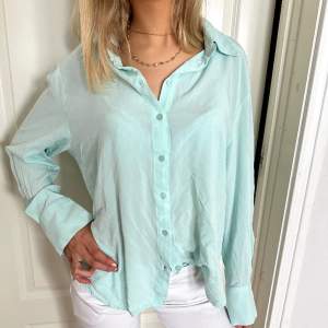 Turkos/ ljusblå skjorta ifrån gina tricot i strlk xl🫶🏼 passar även mindre storlekar om man vill ha den lite oversized💘