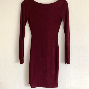 Vinröd långärmad klänning - Djup i ryggen.