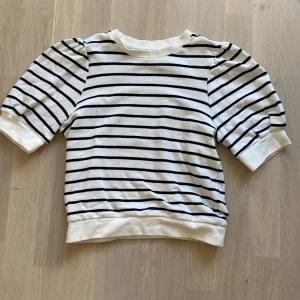 T-shirt med puffärm - Säljer min fina tröja för den har blivit för liten. Tröjan är liten i storleken så skulle mer säga att den är som storlek xxs.  Köpare står för frakt!