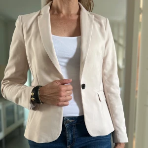 Kavaj i ljusbeige - Figursydd, ljusbeige kavaj från HM i stl 36. Fint skick