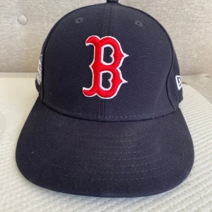 Boston red sox keps  - Säljer en mörkblå Boston red sox keps med world series 04 loggan på. Den är knappt använd och är storlek 56,8cm 