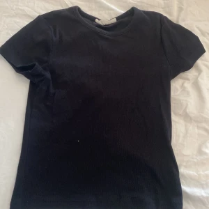 T-shirt  - En vanlig svart T-shirt. Inte alls något tecken på användning använt 1 gång. 