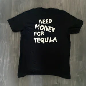 Svart ”Need money for tequila” t-shirt - Den här t-shirten är hur lätt som helst att styla och den är väldigt clean och den har aldrig använts av någon🔥 T shortsen passar både S och M men är i storleken S och skicket på den är 10/10🌟 Hör gärna av dig om du är intresserad🥂