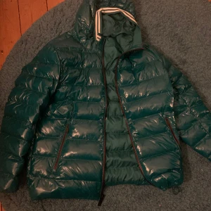 Mk jacka grön - Säljer min mk jacka för riktigt bra pris, jag säljer den då den är för stor för mig och har barat legat i garderoben den senaste tiden. Jackan är nästan helt ny använt 5 gånger, jag säljer den hyfsat billigt för att spännet på jackan är trasigt