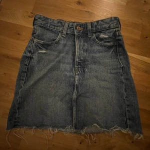 Jeanskjol - Jeanskjol med ”slitna” detaljer. Använd men i mycket fint skick.