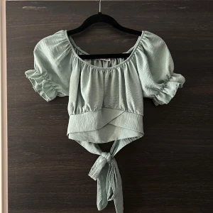 Grön tröja  - Grön tröja med knytning baktill