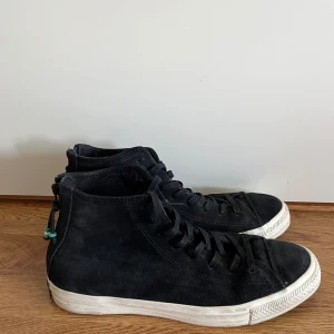 Converse Chuck Taylor Zip Hi 44 skinn - Svarta sneakers i äkta skinn från Converse, modell Zip Hi, special edition, i storlek 44. Skorna är mycket bra skick, mycket sparsamt använda.   Skorna kommer från ett djur- och rökfritt hem. Skorna har inga skador.  