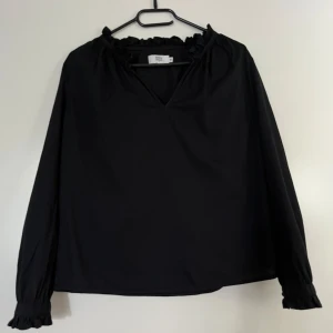 Blus Noa Noa svart 36 - Svart blus med fina detaljer från Noa Noa i mycket bra skick. Storlek 36. 100% bomull.   Mått: Längd ca 58 cm Byst ca 56 cm Midja ca 54 cm Ärmlängd mätt från axel ca 60 cm  Plagget kommer från ett djur- och rökfritt hem. Plagget har inga skador.  