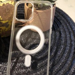Ett helt nytt skal till iPhone 12/12pro - Skalet är oanvänd och kartongen medföljer. Man kan ladda mobilen trådlöst med detta skalet. Materialet är hård plast.