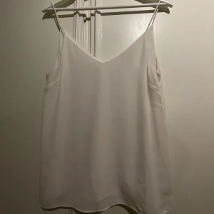 Linne - Vitt linne i med smala axelband. Använt ett antal gånger men i fint skick. 