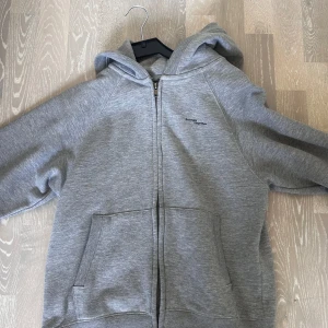 Grå kofta  - Denna kofta har både luva och fickor och passar bra att ha på kvällarna om det blir lite kyligt! 