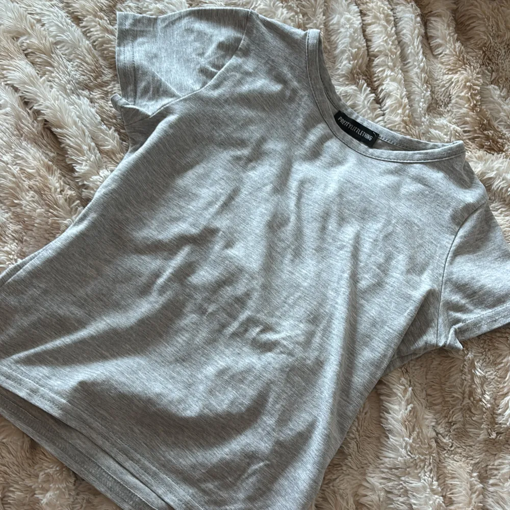 Pretty little thing tshirt i grå som formar fint i storlek xs . T-shirts.