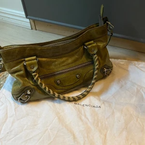BALENCIAGA CITY VÄSKA - Säljer denna otroliga och unika balenciaga city väskan, i en unik olivgrön färg! Dustbag tillkommer 🤩Väskan har ej avtagbart band och saknar skaftet till själva kedjan som lätt går att byta ut, annars är väskan i fint skickVid fler frågor hör av er! 
