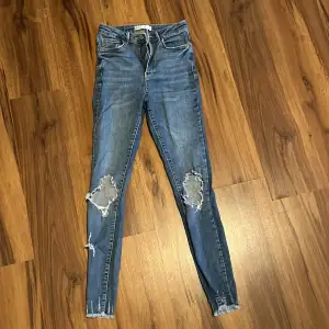 Jeans ifrån Gina Tricot med hål i knäna pch slitningar nertill, strl 36